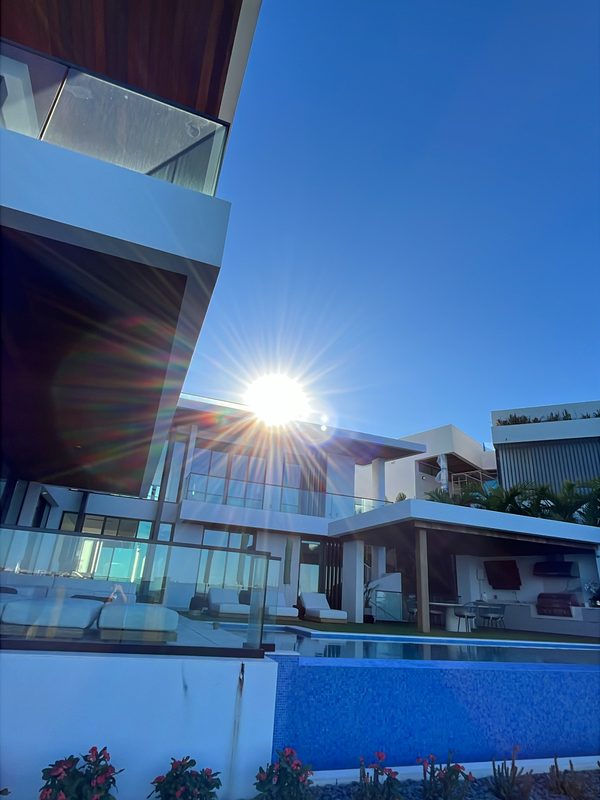 Modern waterfront estate with white exterior walls and pool deck