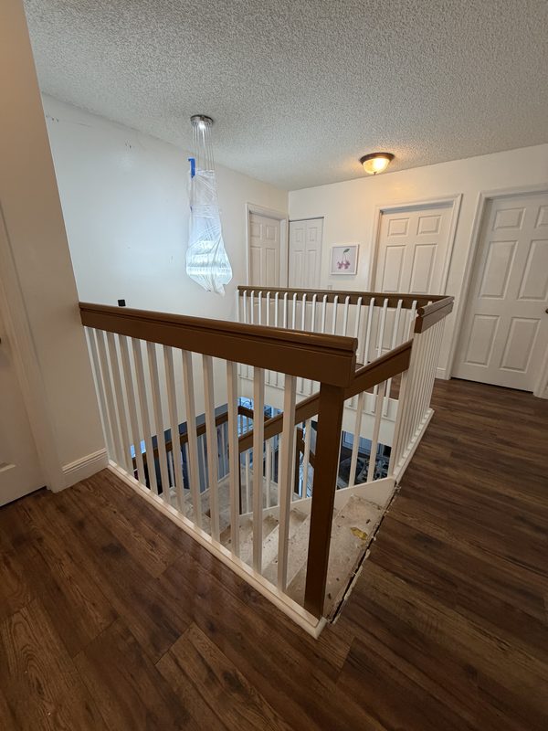 Upstairs landing with white walls, doors and refinished railing